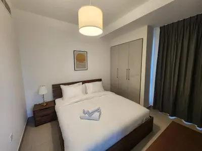a bedroom with a white bed with a pair of shoes on it at 5 bedroom Villa in Maple 2 Dubai Hills Estate in Dubai