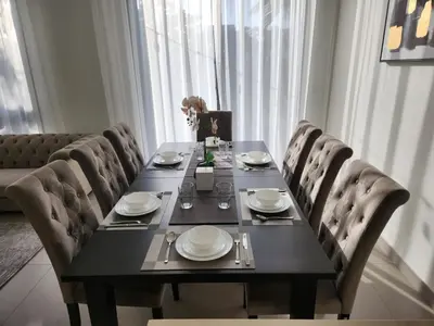 a dining room table with chairs and a table with plates at 5 bedroom Villa in Maple 2 Dubai Hills Estate in Dubai