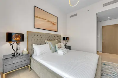 a bedroom with a large white bed in a room at Glamarous 2BR Burj Khalifa & Fountain Views in Dubai