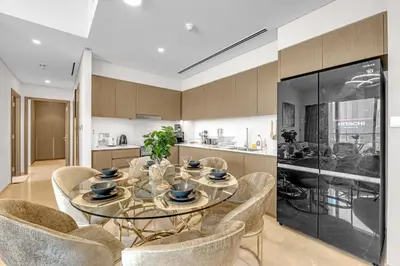 a dining room with a glass table and chairs at Glamarous 2BR Burj Khalifa & Fountain Views in Dubai