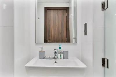 a white sink in a bathroom with a mirror at Elegant Studio on Palm Jumeirah With Stunning Views in Dubai