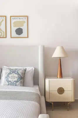 a bedroom with a bed and a nightstand with a lamp at Frank Porter - Jadeel 3 in Dubai