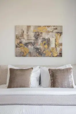 a bed with three pillows and a painting above it at Frank Porter - Jadeel 3 in Dubai