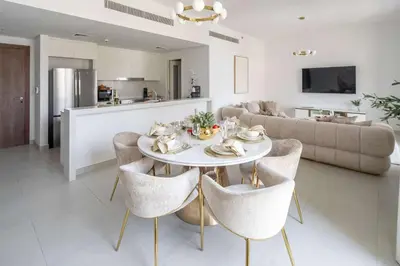 a dining room and living room with a table and chairs at Frank Porter - Jadeel 3 in Dubai