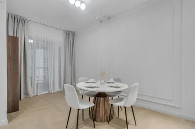 a white dining room with a white table and chairs at Luxury 1BR in Sulafa Tower by EE Holiday Homes in Dubai