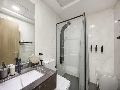 a bathroom with a shower and a sink and a toilet at Livin' Holidays - Studio - Stylish flat in JVC in Dubai