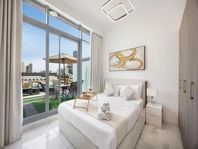 a bedroom with a bed and a large window at Livin' Holidays - Studio - Stylish flat in JVC in Dubai