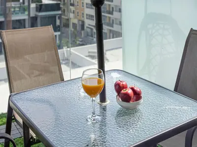 a glass of orange juice on a table with a bowl of fruit at Livin' Holidays - Studio - Stylish flat in JVC in Dubai