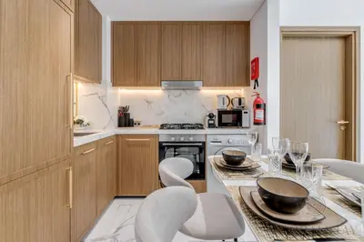 a kitchen with a table with chairs and a stove at GlobalStay Azizi Riviera 67 Apartments Dubai in Dubai