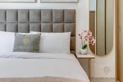 a bedroom with a white bed and a mirror at GlobalStay Azizi Riviera 67 Apartments Dubai in Dubai