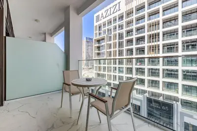 a table and chairs in a room with a large window at GlobalStay Azizi Riviera 67 Apartments Dubai in Dubai