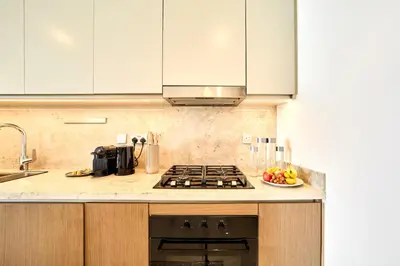 a kitchen with a stove and a bowl of fruit at Luxury 2BR Beach Isle With Palm Views and Beach Access in Dubai
