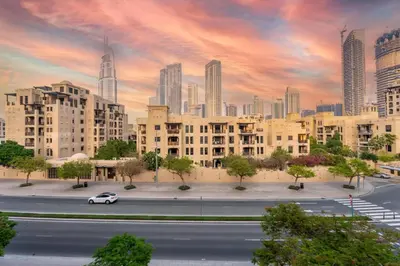 a car driving down a street in a city with tall buildings at GuestReady - 2BR | Downtown Bliss with Burj View in Dubai