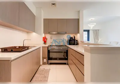 a kitchen with wooden cabinets and a stove top oven at Aspin 3BR Iconic Burj Khalifa Live Fountain View in Dubai