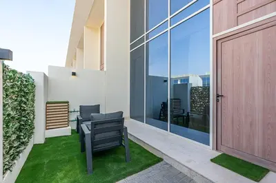 a patio with a bench and a door to a building at Stylish 1BR Villa near Global Village and Golf Clubs in Dubai