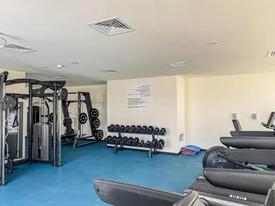 a gym with treadmills and machines in a room at Stylish 1BR Villa near Global Village and Golf Clubs in Dubai