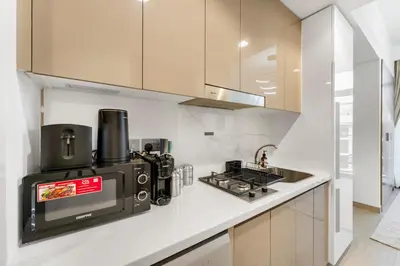a kitchen with a microwave and a stove at Livin' Holidays - Studio - Stylish Stay in Azizi in Dubai