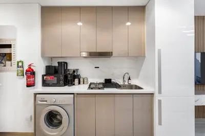 a kitchen with a sink and a washing machine at Livin' Holidays - Studio - Stylish Stay in Azizi in Dubai