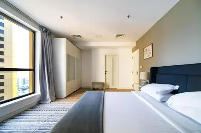 a bedroom with a bed and a large window at SettlerHomes - Stunning JBR 2BR Just 5mins To The Beach in Dubai