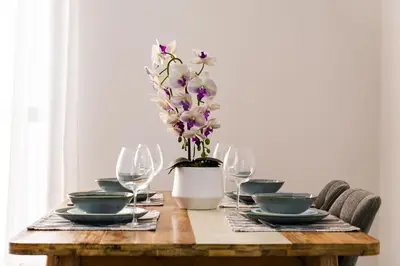a wooden table with glasses and a vase with purple flowers at SettlerHomes - Stunning JBR 2BR Just 5mins To The Beach in Dubai