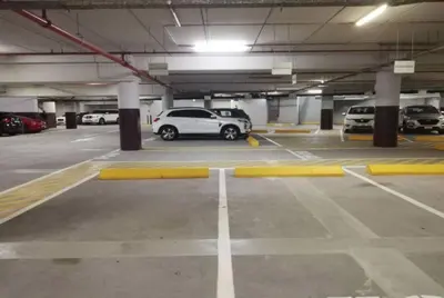 a parking lot with cars parked in a parking garage at SettlerHomes - Stunning JBR 2BR Just 5mins To The Beach in Dubai