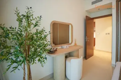 a bathroom with a sink and a mirror and a plant at Private Beach and Pool Vibes at Palace Residences in Dubai