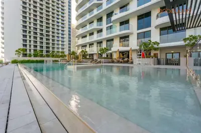 a large swimming pool in front of a building at Private Beach and Pool Vibes at Palace Residences in Dubai