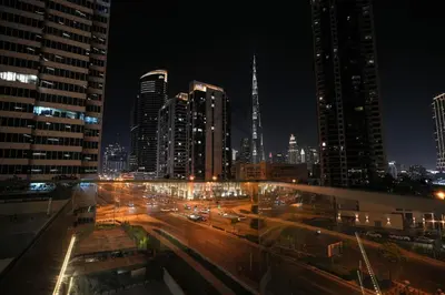 a city skyline at night with buildings and traffic at Marquise Square 410 in Dubai