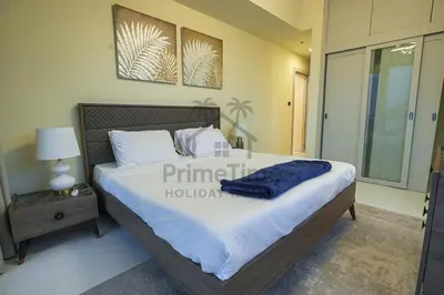 a bedroom with a large bed and a night stand at Al Sahab 4202 in Dubai