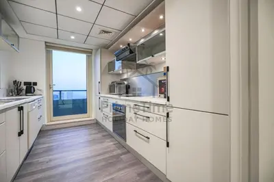 a kitchen with white cabinets and a large window at Al Sahab 4202 in Dubai