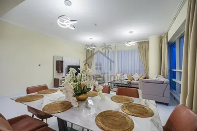 a dining room with a table and chairs and a living room at Al Sahab 4202 in Dubai