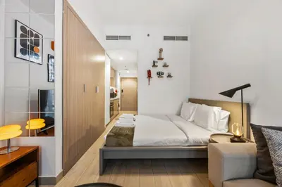 a small bedroom with a bed and a couch at Elite Escape - Stylish Getaway in Azizi Riviera 43 in Dubai