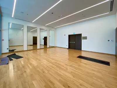 a large room with a wooden floor and white walls at Forte Tower 2, Downtown - 2 Bedroom - Allsopp & Allsopp in Dubai