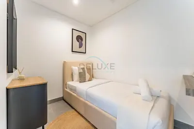 a white bedroom with a bed and a table at Duplex Apartment Next to Zabeel Park, Steps from the Metro Station, and Minutes to Downtown Dubai, Al Kifaf 1 Residences East, Bur Dubai, by Deluxe Holiday Homes in Dubai