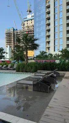 a pool with benches in a city with tall buildings at Exquisite 2BR With Balcony in Business bay in Dubai