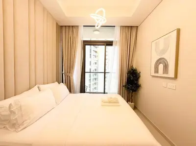 a white bed in a room with a window at Exquisite 2BR With Balcony in Business bay in Dubai