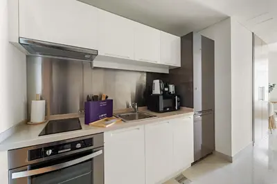 a kitchen with white cabinets and a sink at Silkhaus Chic Studio in Downtown at Claren Tower in Dubai