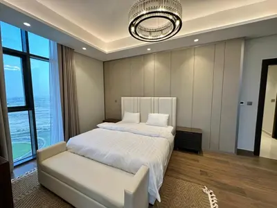 a bedroom with a white bed and a chandelier at Luxury 2BR - Nobles Tower - Business Bay in Dubai