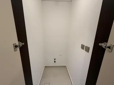 a bathroom with a toilet in a white wall at Luxury 2BR - Nobles Tower - Business Bay in Dubai