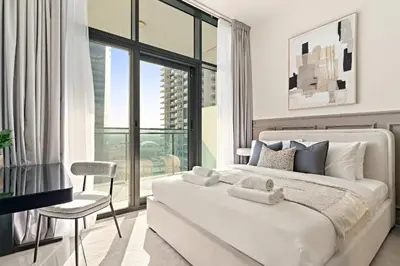a bedroom with a large white bed and a window at Silkhaus Modern 2BR in Merano Tower in Business Bay in Dubai