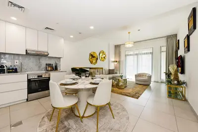 a kitchen and living room with a table and chairs at Luxury 1BD Stay in Lamtara 2, Near Jumeirah Burj in Dubai