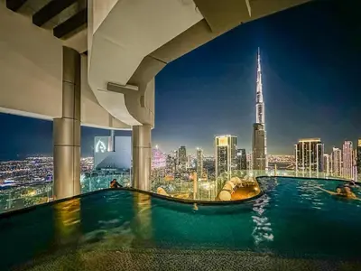 a swimming pool in a building with a view of a city at CH Burj Khalifa View Pool 1BR Paramount Escape in Dubai