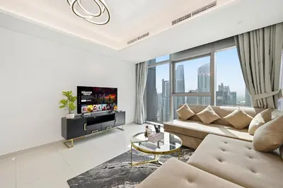 a living room with a couch and a tv at CH Burj Khalifa View Pool 1BR Paramount Escape in Dubai