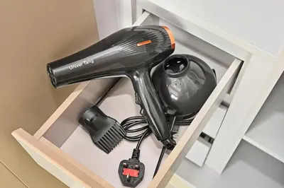 a hairdryer and a hair dryer in a shelf at CH Burj Khalifa View Pool 1BR Paramount Escape in Dubai