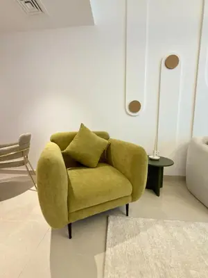 a green chair in a living room with a lamp at Duja Tower 4405 in Dubai