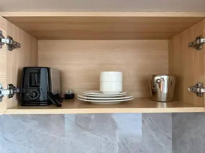 a shelf with a microwave and a coffee maker and plates at Luxery Hotel Apartment l Novotel Residence l JVT in Dubai