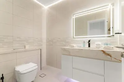 a white bathroom with a toilet and a sink at FIRST CLASS 2BR Elegant Duplex Haven in Dubai