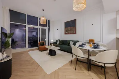a living room with a green couch and a table and chairs at Waterfront Serenity in Dubai Marina in Dubai