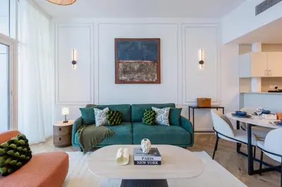 a living room with a green couch and a table at Waterfront Serenity in Dubai Marina in Dubai