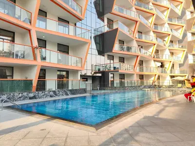 a swimming pool in front of a building at Cozy Modern 1BR with Dubai Skyline View in Dubai